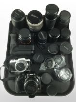 A collection of cameras and lenses including Lumix, Sony Alpha 7 camera body, Sigma,