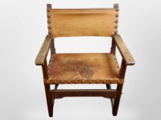 An early 20th-century Danish oak-framed armchair upholstered in studded tan leather, width 68cm.