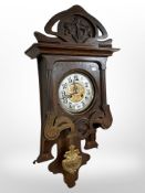 An early 20th-century continental carved oak 8-day wall clock with silvered dial, height 85cm.