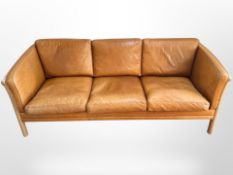 A late 20th-century Danish beech-framed stitched tan leather three-seater settee,