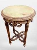 A heavily carved beech onyx-topped circular occasional table, height 69cm.