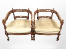 A pair of 20th-century horseshoe-shaped armchairs with tasselled cushions, each 65cm x 68cm x 72cm.
