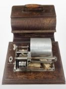 A cylinder gramophone in carved oak case.