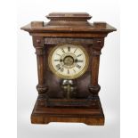 A carved and stained pine 8-day mantel clock, height 35cm.