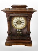 A carved and stained pine 8-day mantel clock, height 35cm.
