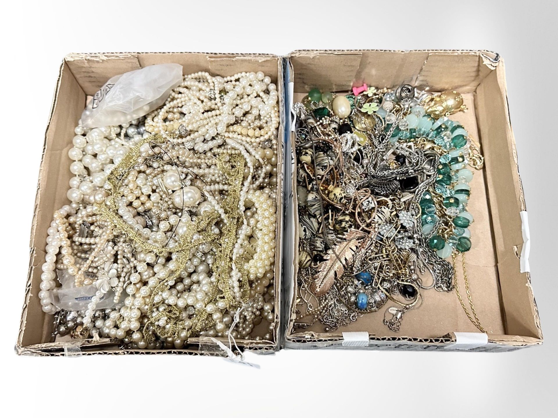 A box of various stone and metal necklaces together with a box of faux and cultured pearls.