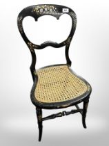 A 19th-century ebonised gilt and mother of pearl-inlaid occasional chair with bergere seat.