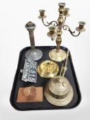 A group of metal wares including a die-topped paperweight, a brass squat candlestick,