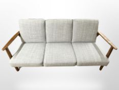 A contemporary Danish stained beech-framed three-seater settee in grey upholstery,