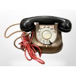 A vintage copper and Bakelite telephone.