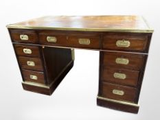 A late 19th-century continental campaign-style mahogany and brass-mounted twin-pedestal desk with