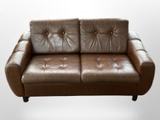 A 1970s Danish two-seater low settee upholstered in buttoned brown leather, 145cm x 80cm x 73cm.