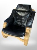 A late 20th century Danish beech framed armchair with stitched black leather seat,