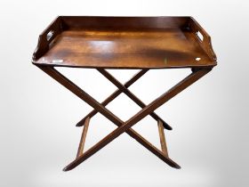 A mahogany serving tray on folding stand, 75cm x 44cm x 82cm.