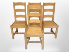 A set of four contemporary oak dining chairs.