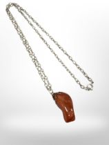 A polished chunk of amber mounted on chain.