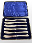 A cased set of six silver-handled butter knives.