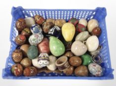 A crate containing polished hardstone eggs, further painted and ceramic examples, paperweights.