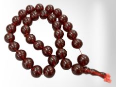 An impressive large cherry amber necklace with thirty three large spherical beads,