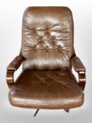 A 20th-century Danish laminated and bent-beech-framed swivel armchair upholstered in buttoned brown
