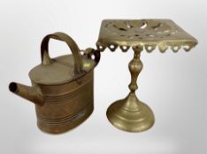 A brass trivet and a watering can.