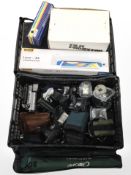 A crate containing assorted cameras, video camera, tripods, accessories.