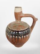 A painted terracotta wine jug, height 33cm.