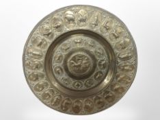 A large embossed brass charger, diameter 60cm.