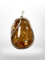 A Baltic amber pendant mounted in white metal, 32.9g, length 62 mm.