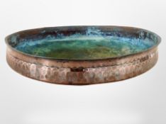 A 19th-century hammered copper shallow bowl, diameter 33cm.