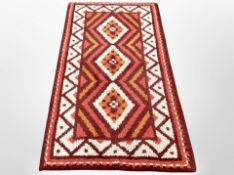 A 1970's woolen rug of Eastern design,