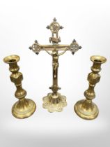 A 19th-century brass crucifix, height 38cm, together with a pair of candlesticks.