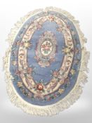 A Chinese oval rug on blue ground,