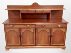 A reproduction mahogany effect sideboard, fitted cupboards and drawers, width 154cm.