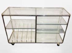 A metal and glass multi tier trolley on castors,