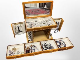 A contemporary multi-compartment jewellery box containing assorted silver and costume jewellery,