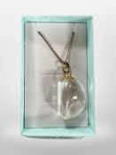 A polished rock crystal pendant on silver gilt chain.
