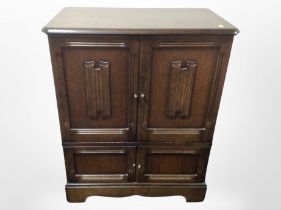 A reproduction oak linen fold double door cabinet,