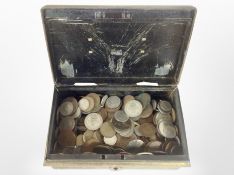 An antique cash tin containing assorted coins.
