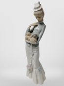 A Lladró figure of a lady holding a Pekingese dog.
