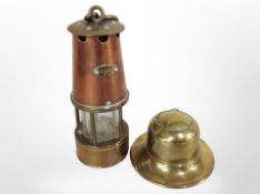 A miniature brass and copper miner's lamp, together with a brass inkwell.