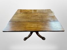 A George III mahogany drop leaf dining table on carved lion paw feet,