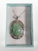 A silver pendant on chain with polished Cabochon green stone.