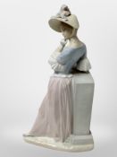 A Lladró figure of a lady leaning against a column holding a parasol, height 39cm.