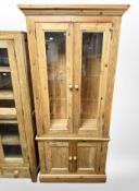 A pine glazed double door cabinet,