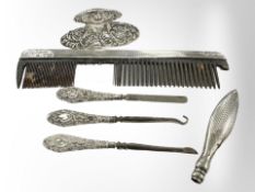 A small group of silver items including comb, button-hooks,