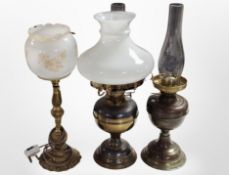 Two brass oil lamps and a table lamp.