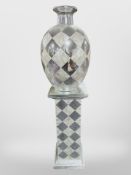 A contemporary silvered pedestal with matching vase,