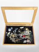 A glazed jeweller's display cabinet containing assorted costume jewellery, bead necklaces,