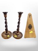 A pair of oak barley twist candlesticks, height 32cm, together with a Maelzel French metronome.